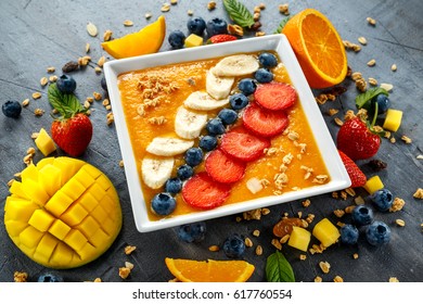 Fresh Orange Smoothie In Bowl For Breakfast With Blueberries, Granola, Mango, Strawberry And Banana