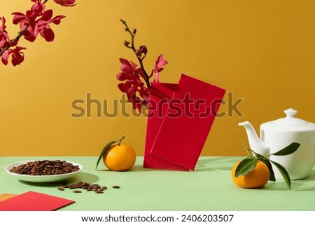 Fresh orchid branches decorate the background. A plate of melon seeds, a pot of tea, tangerines and lucky money envelopes are displayed on the table. Front view.