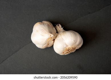 Fresh Organic Garlic Bulbs On A Dark Stone Countertop, Overhead View