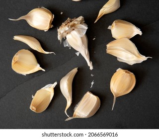 Fresh Organic Garlic Cloves On A Dark Stone Countertop, Overhead View