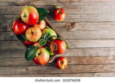 Fresh organic green and red apples in the wooden box. On rustic wooden background. Free space for text. Top view