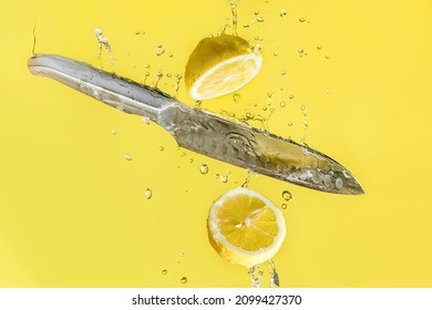 fresh organic lemon cut with a knife in water drops isolated over bright yellow background, healthy eating or diet, summer drink or refreshment beverage concept. High quality photo