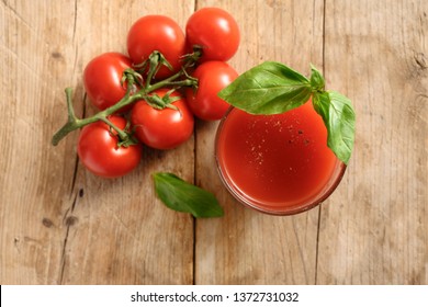 Fresh Organic Tomato Juice In A Drinking Glass With Basil Garnish On A Rustic Wooden Board, Healthy Smoothie Drink With Copy Space, Selected Focus, Top View From Above