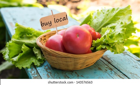 Fresh organic tomatoes and  lettuce in bucket on garden background. Natural/eco/bio/organic products. Selective focus. Tag with word buy local.