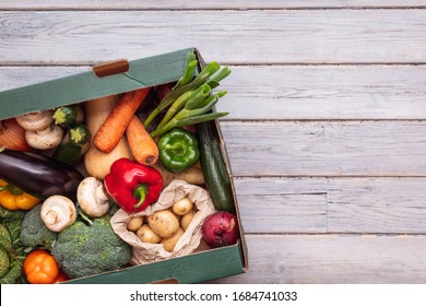 Fresh organic vegetable delivery box on a wooden background