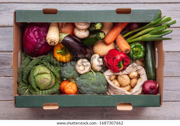Fresh organic vegetable delivery box on a\
wooden background