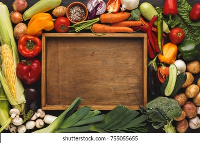 Fresh organic vegetables and wooden box with copy space background. Healthy natural food. Tomato, leek, carrot, pepper, potato and other cooking ingredients top view