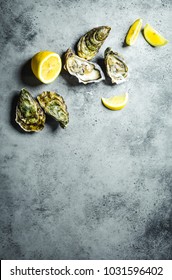 Fresh Oysters, Lemon Wedges. Rustic Stone Background. Opened Fresh Raw Oysters. Top View. Copy Space. Oyster Bar. Seafood. Oysters Concept. Party Food. Space For Text. From Above 