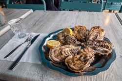 Fresh Oysters On Blue Plate, With Lemon And Ice. Healthy Seafood. Served Table In Restaurant Close To Oyster Farm In France