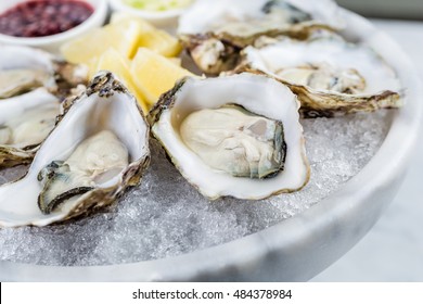 Fresh oysters platter with sauce and lemon - Powered by Shutterstock