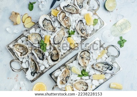 Fresh oysters platter with sauce and lemon. Oyster dinner with champagne in restaurant. Food recipe background. Close up.