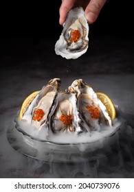 Fresh oysters in smoke dry ice plate with lemon.