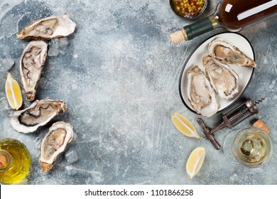 Fresh oysters and white wine on stone table. Top view with space for your text