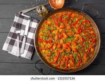 Fresh paella in pan on wooden table