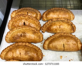 Fresh pasties, out of the oven, on baking sheet, placed on a cooling rack