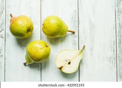 Fresh Pears And Half Pear On The White Wooden Background.  Top View