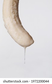 Fresh peeled banana dripping milk shake, sperm donation concept, banana looking like penis and semen