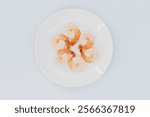 Fresh peeled shrimp on a white ceramic plate against a white background, seafood, shrimp, กุ้ง