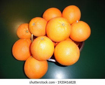 Fresh Picked Navel Oranges, In A Silver Bowl On Green Countertop.