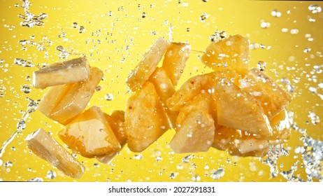 Fresh pineapple flying with water splashes on yellow gradient background - Powered by Shutterstock