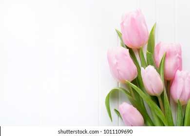 Fresh Pink Tulip Flowers Bouquet On Shelf In Front Of Wooden Wall.