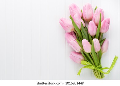 Fresh Pink Tulip Flowers Bouquet On Shelf In Front Of Wooden Wall.