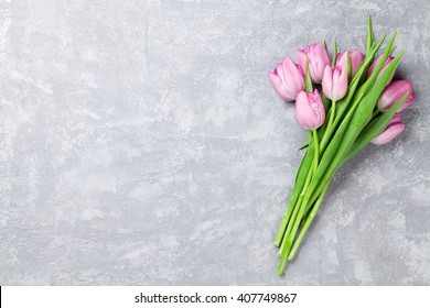 Fresh Pink Tulip Flowers On Stone Table. Top View With Copy Space