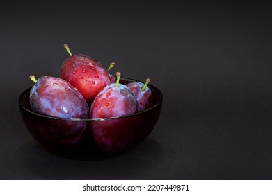 Fresh plum. Autumn harvest. Ripe purple plums in glass bowl on dark background. Concept: seasonal fruits, healthy food. Close up. Copy space for text
 - Powered by Shutterstock