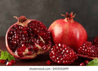 Fresh pomegranates and green leaves on wooden table, closeup - Powered by Shutterstock