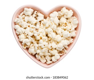 Fresh popcorn in heart shaped bowl isolated on white