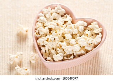 Fresh popcorn in heart shaped bowl