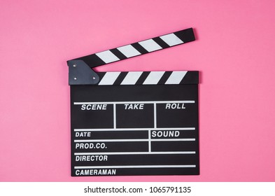 Fresh Popcorn And Movie Clip Isolated On Pink Background Top View With Copy Space Around Products. Cinematic Concept For Blogs Or Design