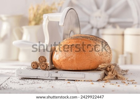Fresh poppy seed bread on white bread slicer . Bread in the countryside.