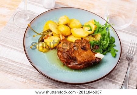 Fresh portion of confit de canard served on plate with greenery.