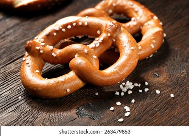 Fresh pretzels with sea salt close-up on  dark board background
