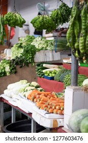 Fresh Produce In The Market. Rows Of Vegetables In The Market. Wet Market In Asia. Carrots And Rows Of Green Vegetables Hanging At The Market.