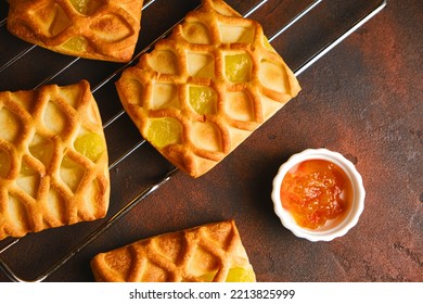 Fresh Puff Pastry Mini Pies With Pear And Lime Jam Filling On Roasting Rack On Dark Background, Horizontal View From Above, Flatlay