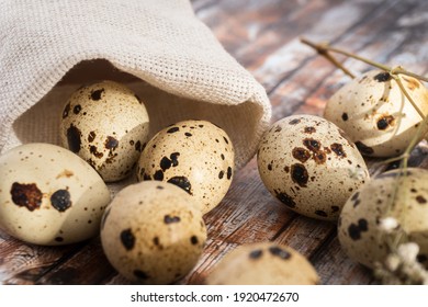 Fresh quail eggs on a brown wooden table. Raw quail eggs close-up on a culinary background. Concept of preparation for cooking. selective focus