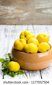 Fresh  quince fruits on white wooden table 