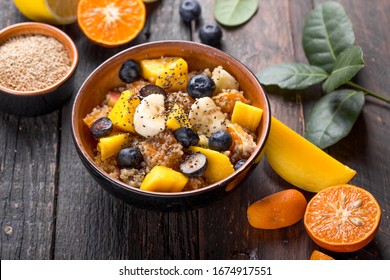 Fresh quinoa organic fruit salad in bowl on wooden  background. Helthy superfood detox concept.  Vegan/vegetarian food. Space for text. Top view