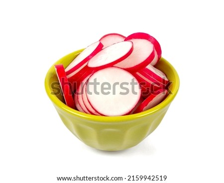 Fresh radish isolated on white background. Slices of freshly cut radish in a green bowl.
