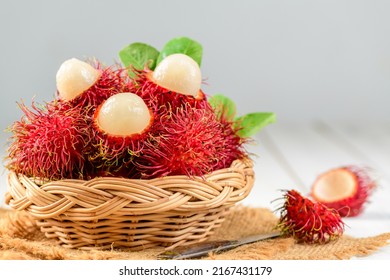 Fresh Rambutan fruits with leaves in bamboo basket on wood background. fruit Southeast Asia in summer season