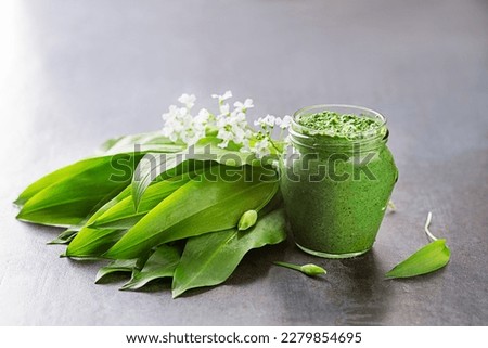 Fresh ramson or wild garlic pesto in glass jar close up. Healthy spring food concept