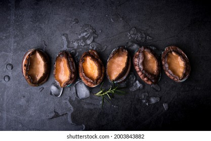 Fresh raw abalone on black background - Shutterstock ID 2003843882