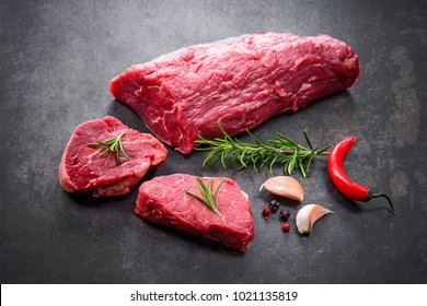 Fresh and raw beef meat. Whole piece of tenderloin with steaks and spices ready to cook on dark background  - Shutterstock ID 1021135819