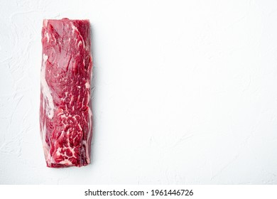 Fresh and raw beef meat. Whole piece of tenderloin with steaks set, on white stone background, top view flat lay, with copy space for text