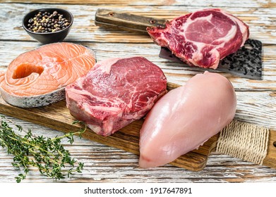 Fresh Raw Beef Striploin Steak, Chicken Breast Fillet, Pork And Salmon Steak. White Wooden Background. Top View