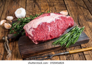 Fresh Raw brisket beef meat prime cut on a wooden board with herbs. wooden background. Top view