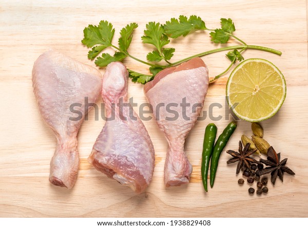 Fresh\
Raw chicken legs isolated on a Wooden\
background