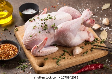 Fresh raw chicken on cutting board and spices for cooking - Shutterstock ID 1070942093